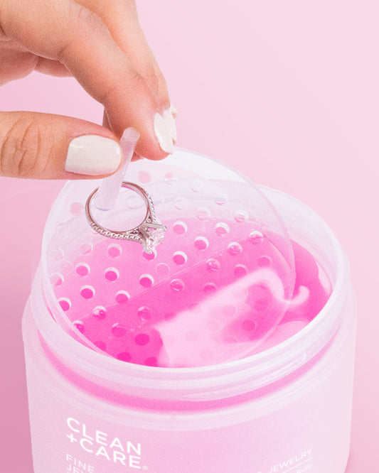 Hand dripping a diamond ring & jewelry dipping basket into a jar of Fine Jewelry Cleaner