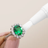 Clean + Care's Jewelry Cleaning Stick in use on an emerald and diamond ring