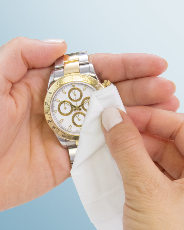Jewelry + Watch Cleansing Wipes cleaning a gold and silver watch