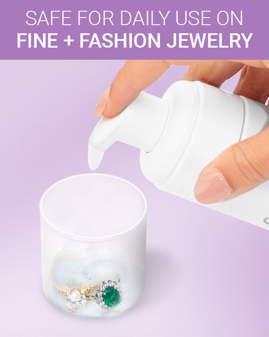 CLEAN+CARE Foaming Jewelry Cleaner in-use with diamond and emerald rings being soaked in cap