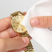Hands holding a gold watch and polishing with a Microfiber Cleaning Cloth