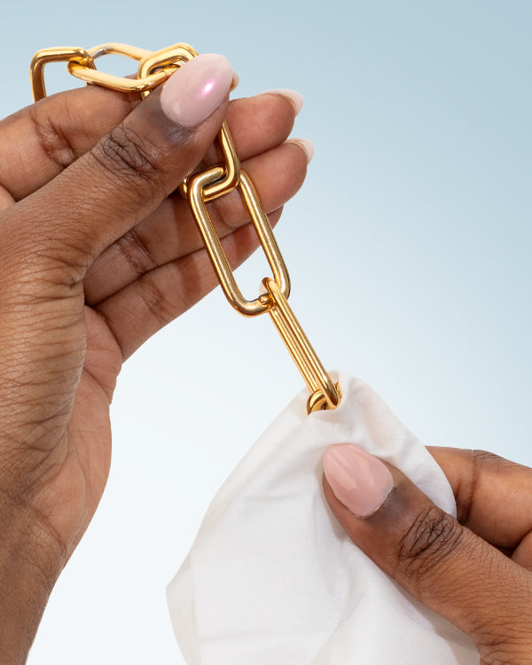 Jewelry + Watch Cleansing Wipes in use on a gold chain